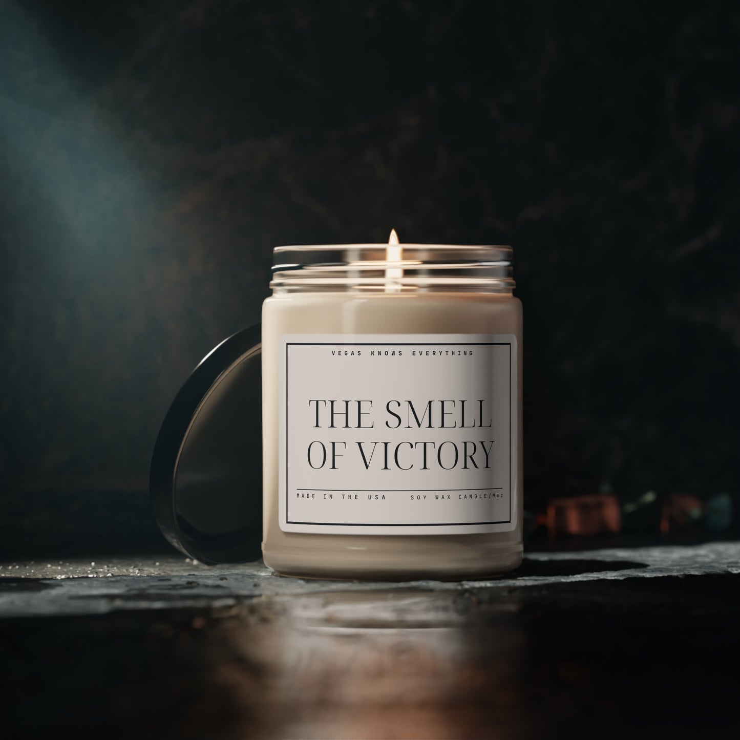 9 ounce soy candle with label that reads "The Smell of Victory" made in the USA mock up photo with candle lit.